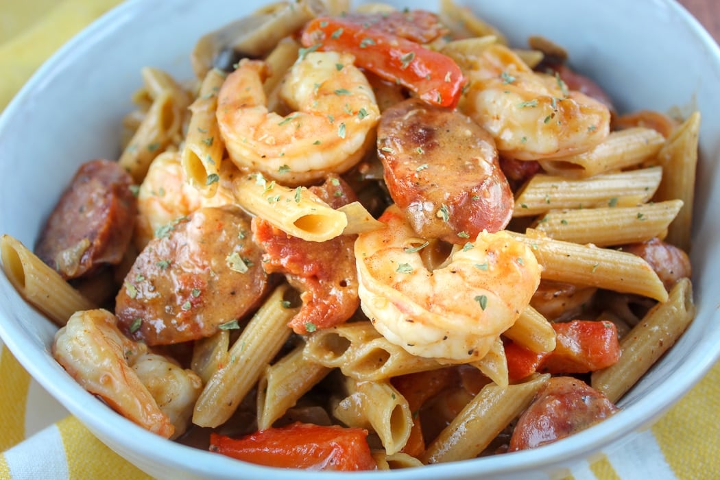 This Cajun Shrimp and Sausage Pasta is quick to make and you can have it as spicy as you like! Fat Tuesday and Mardi Gras won't know what hit 'em! Pasta mixed with shrimp, andouille, onions, peppers & mushrooms all smothered in a spicy creamy tomato sauce! It's heavenly!