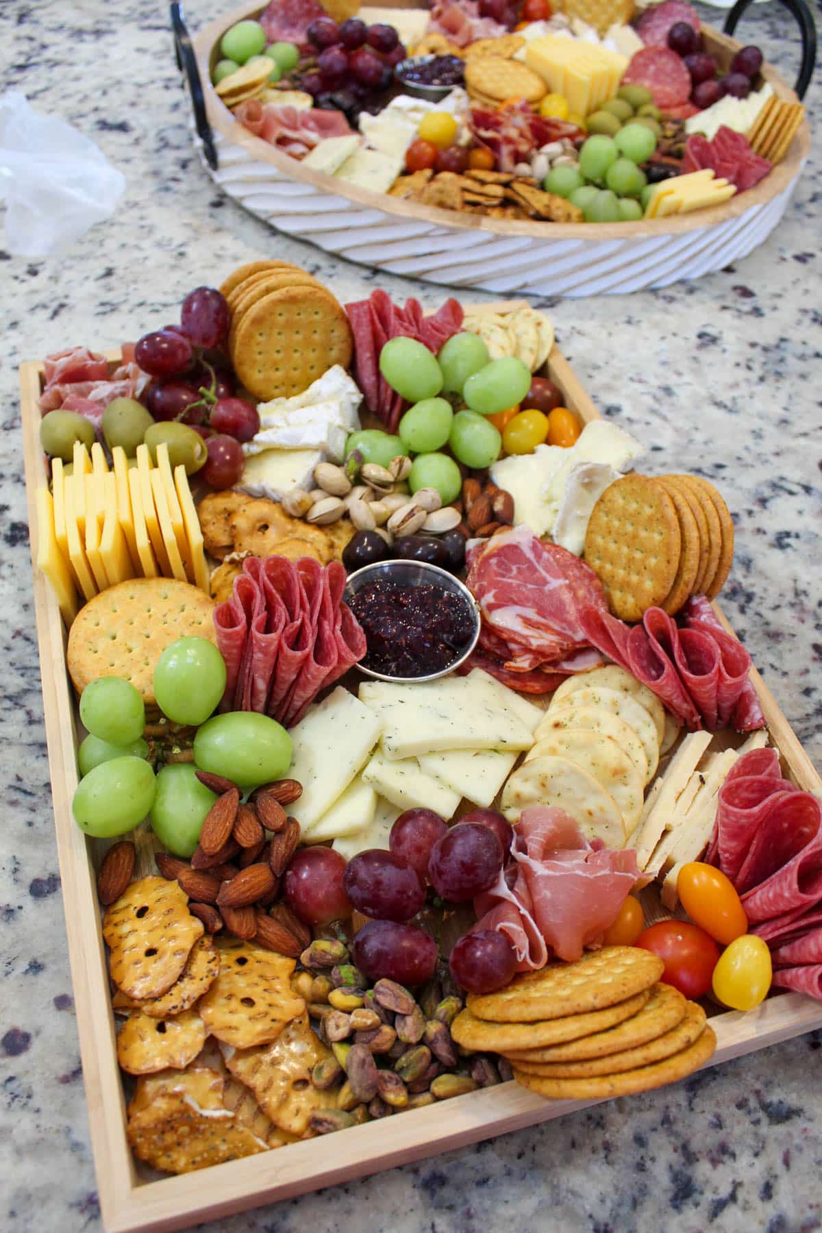 Finished charcuterie board piled with meats, cheeses, crackers, fruit, nuts and olives