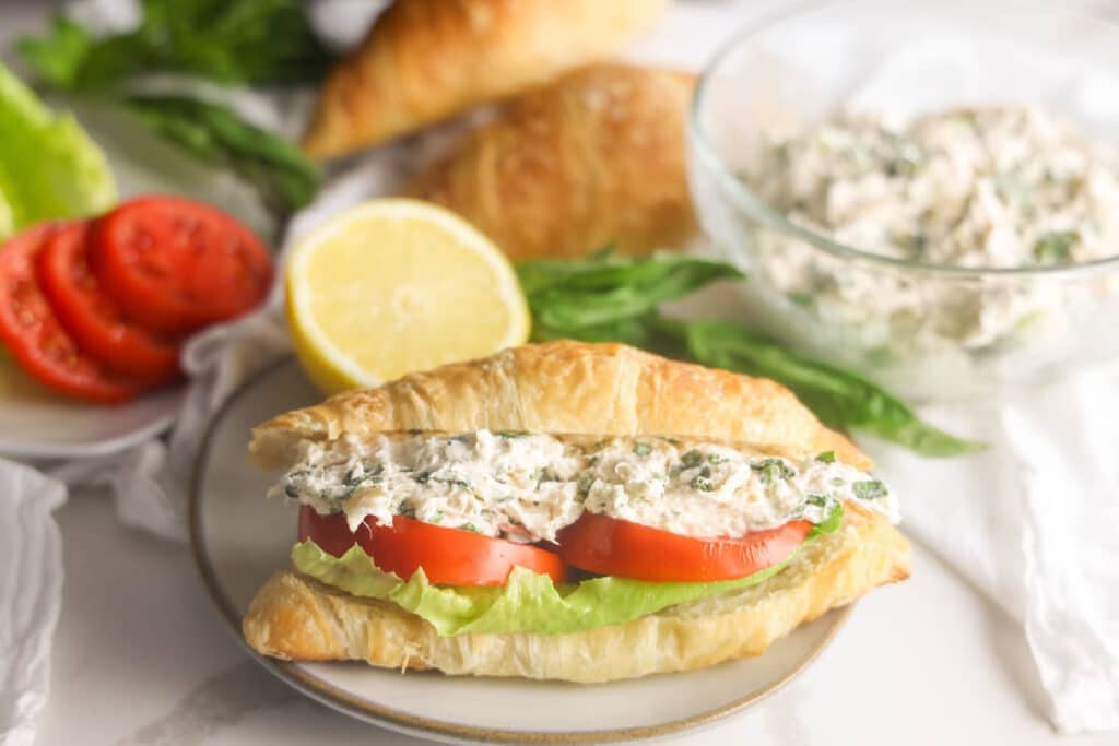Lauryn's Lemon Basil chicken salad sandwich on a croissant with lettuce and tomato