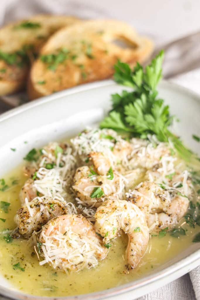Copycat Carrabba's Shrimp Scampi in a rimmed dish with lemon butter sauce, parsley and Parmesan