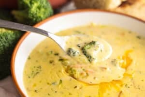Spoonful of copycat Panera Broccoli Cheddar Soup with broccoli and carrots