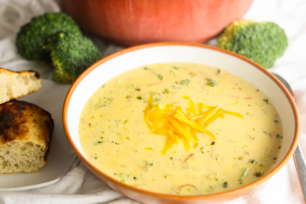 Copycat Panera Broccoli Cheddar Soup in a bowl topped with shredded cheddar cheese