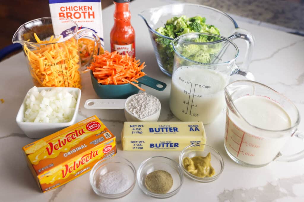 Ingredients for copycat Panera Broccoli Cheddar Soup including Velveeta, sharp cheddar, broccoli and carrots