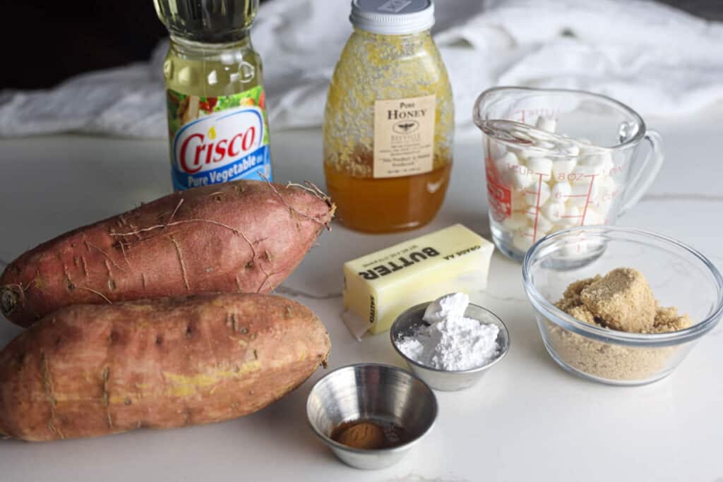 Ingredients for Texas Roadhouse loaded sweet potatoes, including sweet potatoes, butter, brown sugar, powdered sugar, honey, cinnamon and mini marshmallows.