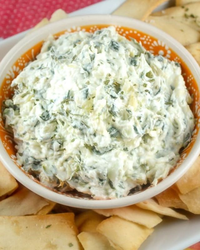 Happy National Chip And Dip Day! This Spinach Artichoke Parmesan Dip is a perfect dip for your next party! La Terra Fina’s dip is at a lot of grocery stores but this copycat version is even better! It is super simple to make and delicious. The best part is – I have a great idea for using up the leftovers too! #spinachdip #chipsanddip #easyrecipes #appetizers #cookingathome #partyfood