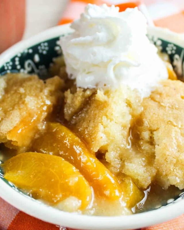 This Smoked Peach Cobbler will be a favorite dessert for the whole family! Frozen peaches, a delicious cake batter and a secret ingredient crunchy sugar topping! #peaches #peach #cobbler #dessert #sweettooth #cookingathome #foodofig